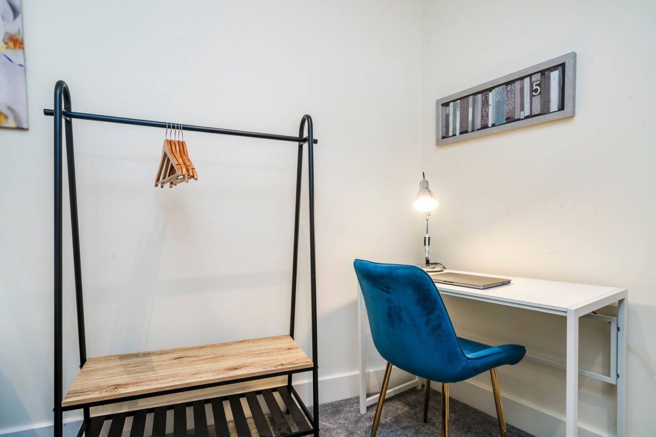 Une pièce comprenant un lit, un bureau, une chaise et une étagère fixée au mur.