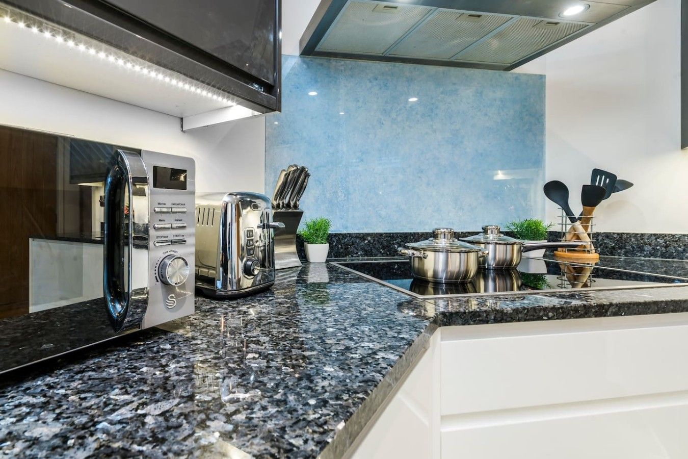 A modern kitchen with a built-in microwave, toaster, and stove.
