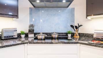 A modern kitchen with a built-in stove, a toaster, and a knife block.
