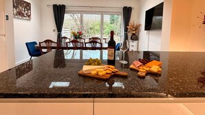 A kitchen with a marble countertop, a wine bottle, and a glass of wine. - CosyRiverside House: Contractors, tourists free parking (Hemel Hempstead)