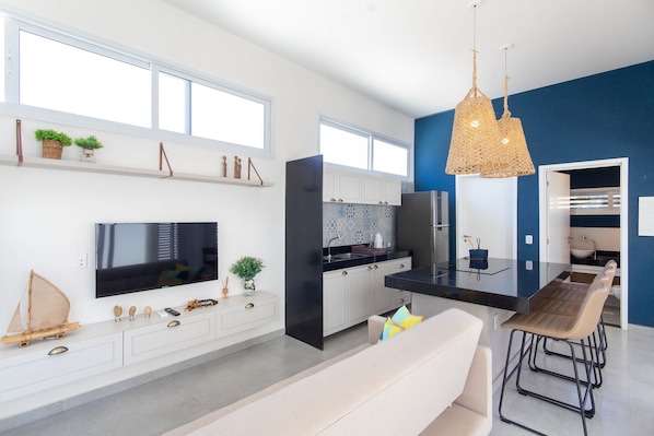 A modern kitchen with a large window, built-in appliances, and a dining area with bar stools.