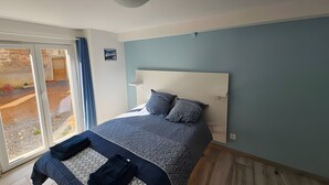 Una camera da letto con un letto, una luce a soffitto, vista attraverso una porta scorrevole e una piccola mensola.