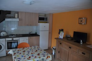 Una cocina compacta equipada con microondas, refrigerador, horno y lavadora.