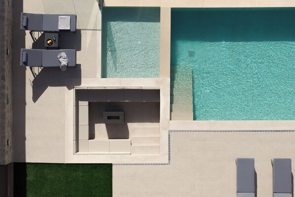 An aerial view of a swimming pool area with lounge chairs and a water feature.