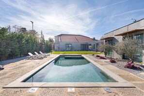 A swimming pool with lounge chairs, a house with a tiled roof, and a well-maintained lawn. - Apartment 'T2 Familiar Ua01' with Shared Pool, Wi-Fi and Air Conditioning (Palmeira)