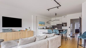 Ein modernes Wohnzimmer mit einem grauen Ecksofa, einer Holzkassette und einem flachbildschirmfernseher an der Wand.