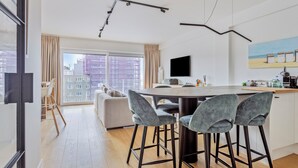 Eine moderne Küche mit Essbereich, großen Fenstern und Blick auf die Stadt.