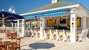 A poolside bar with outdoor seating and umbrellas. - Cozy 1-bedroom studio in peaceful Myrtle Beach w/ AC, indoor, outdoor pool& more (Myrtle Beach)