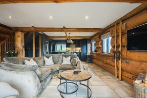 Ein gemütlicher Wohnbereich mit einer Sofagarnitur, einem Couchtisch und einer Holzwand.