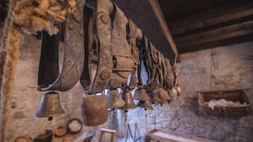 A series of bells hanging from a beam, wooden beams, and a stone wall.