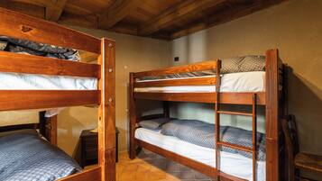 A bunk bed room with wooden frames and a tiled floor.