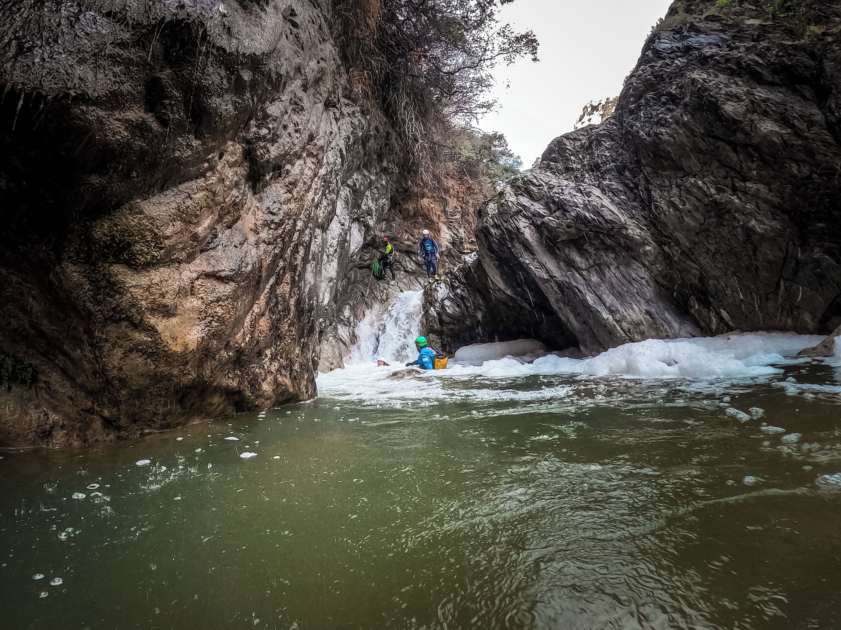 A narrow canyon with rocky walls and a river.