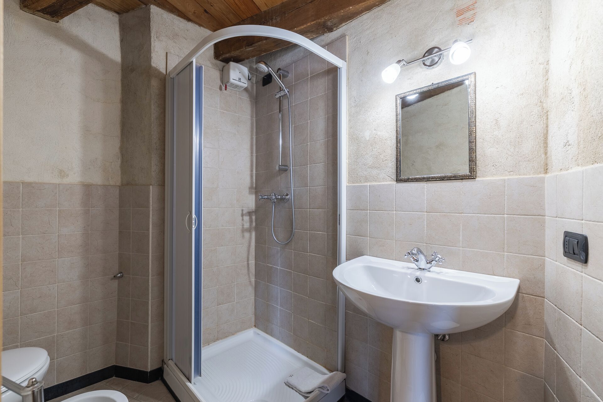 Une salle de bain avec douche, toilettes et lavabo.
