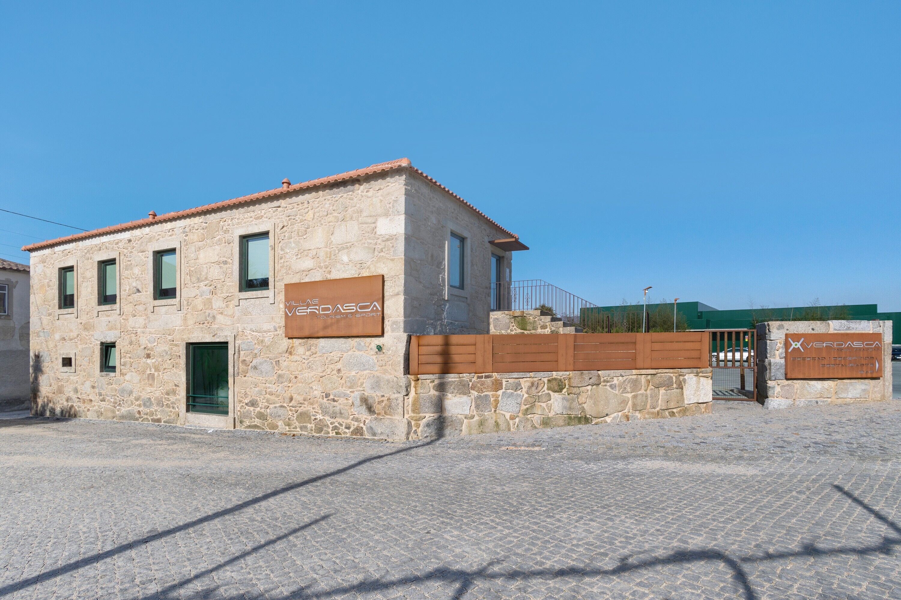 Un bâtiment en pierre avec une enseigne portant l’inscription « VERDASCA » et une entrée fermée par un portail.