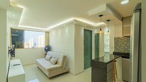 Un apartamento moderno con sofá, kitchenette y vistas a la ciudad.