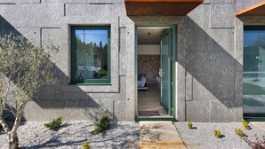 Un bâtiment moderne avec une façade en pierre, une porte en bois et une fenêtre.