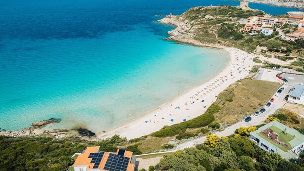 An aerial view of a coastal area with a beach, buildings, and a rocky coastline. - Accommodation 1 km From the Beach (Santa Teresa di Gallura)