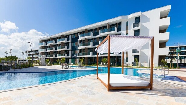 Ett modernt hotell med en swimmingpool, utomhusplats och ett takförsett område.