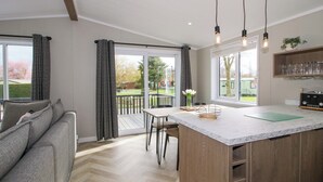 Een moderne keuken met een marmeren aanrecht, houten kastjes en uitzicht op de omgeving.