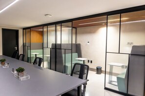 A modern conference room with a long table, chairs, and glass partitions. - Move #914 - Apartamento Comfort by Carpediem (João Pessoa)