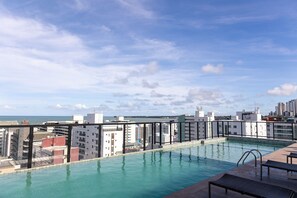 A rooftop pool with a city view, surrounded by modern buildings. - Move #914 - Apartamento Comfort by Carpediem (João Pessoa)