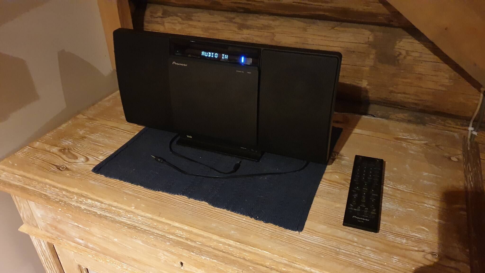 Un système audio Pioneer posé sur une surface en bois, avec une télécommande.