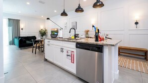 A modern kitchen with white cabinetry, a stainless steel dishwasher, and pendant lighting. - Sunny Dreams Vacation Home 3 miles to Disney 7574 (Kissimmee)