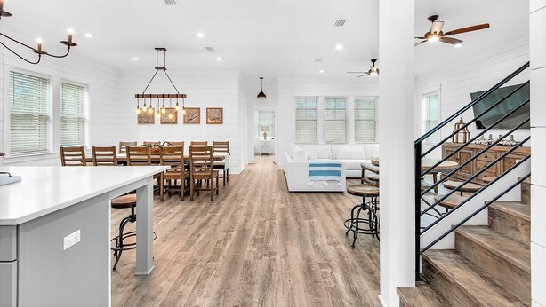 A spacious kitchen with a central island, wooden flooring, and modern lighting fixtures. - Latitude! New! 8 Bed! Beach! (Destin)