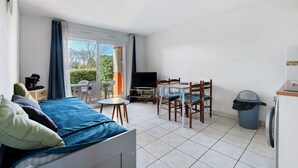 Ein Zimmer mit Bett, Tisch mit Stühlen, Fernseher und einem Balkon mit Blick.
