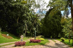 A pathway in a park with directional signs and a lamppost.
