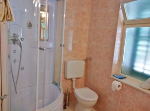 A bathroom with a shower, toilet, and a window. - Guest House Hazdovac Apartment (Mljet)