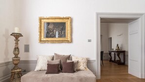 A room with a beige sofa, a framed painting, and a wooden floor. - Dimora Torremuzza historic home downtown Palermo with three bedrooms and 4 bathrooms (Palermo)