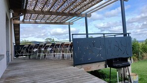 Un espacio de estar techado al aire libre con sillas y una parrilla.