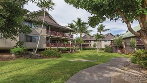 A hotel with a two-story building, a covered outdoor area, and a well-maintained lawn.