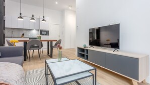 A modern apartment with a kitchen, dining area, and living room. - Cozy 1BR Retreat Steps from Sol & Santa Ana (Madrid)
