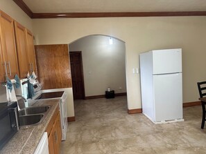 A kitchen with wooden cabinets, a white refrigerator, and a sink. - Bay Nassau
SPACIOUS escape to quiet, getaway in Yamacraw Beach, Nassau, Bahamas (Nassau)