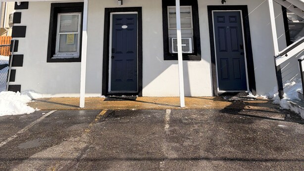 Un edificio a due piani con un balcone, diverse finestre e una porta.