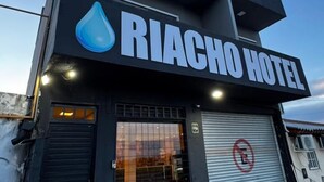 Un edificio con un letrero que dice "RIACHO HOTEL" y un logotipo con forma de gota de agua.