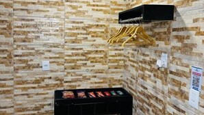 Una habitación con pared de piedra, un mueble negro con aperitivos y una lámpara en el techo.