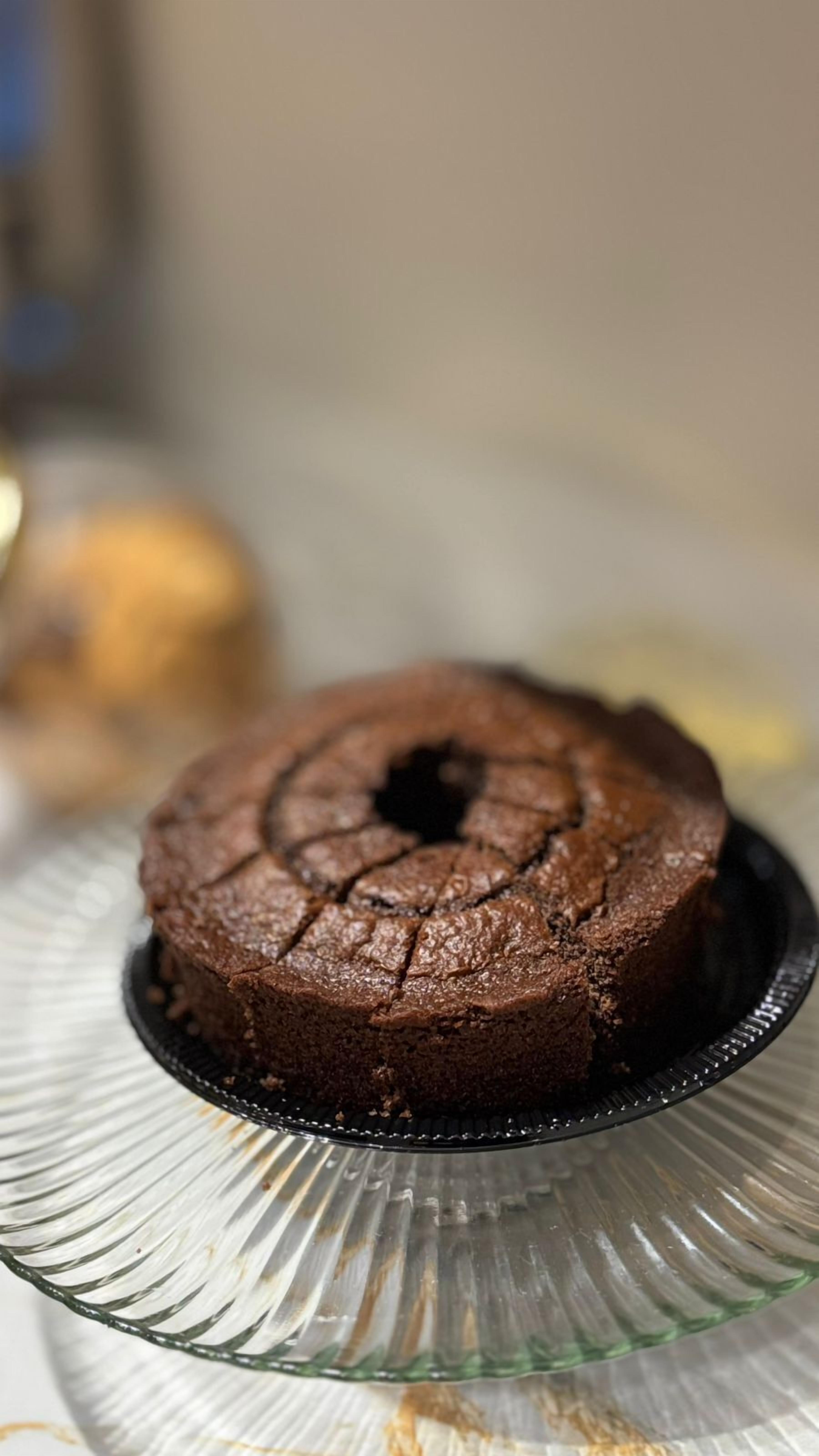 A chocolate bundt cake on a glass plate.