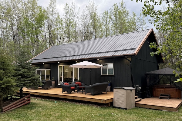 Brand-new 12x44’ front deck with cozy outdoor seating and peaceful forest surroundings.