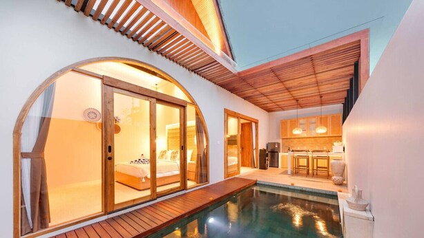 A modern hotel room with a private pool, wooden deck, and a kitchen area visible through an open door. - Stylish 2BR Villa near Central Ubud (Ubud)