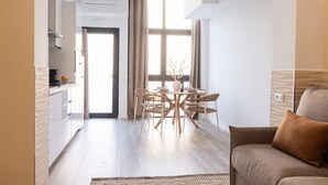 Een moderne woonkamer met een bank en een eethoek met een tafel en stoelen.