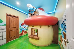 A children's play area with a large mushroom-shaped playhouse, a wooden door, and a green floor. - 10BR house with private pool in Paradiso Grande (Orlando)