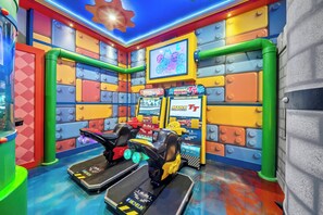 A colorful arcade with racing game machines, a neon sign, and a LEGO-themed wall. - 10BR house with private pool in Paradiso Grande (Orlando)