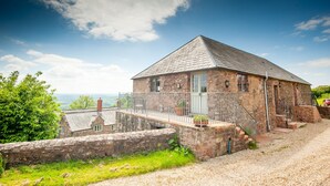Un bâtiment en pierre doté d’un balcon et offrant une vue sur la campagne.