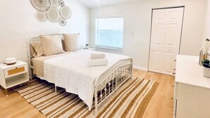 A bedroom with a bed, bedside table, and a hanging light fixture. - Cozy Multi-level Townhome South Tampa 2BD2BA (Tampa)