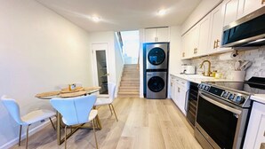 A modern kitchen with a built-in washer and dryer, a stainless steel oven, and white cabinetry. - Cozy Multi-level Townhome South Tampa 2BD2BA (Tampa)