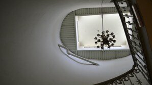 Una escalera de caracol con barandal blanco y un ventanal en la parte superior.