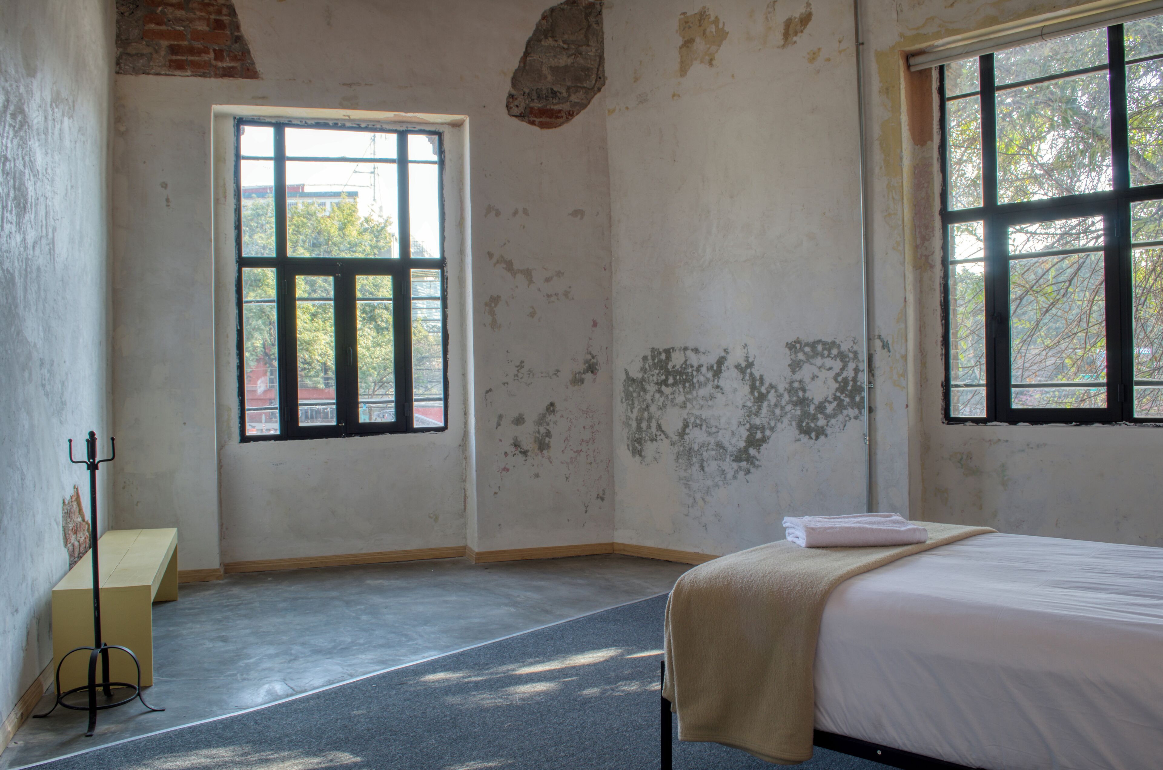 A room with a bed, a window, and a small table.